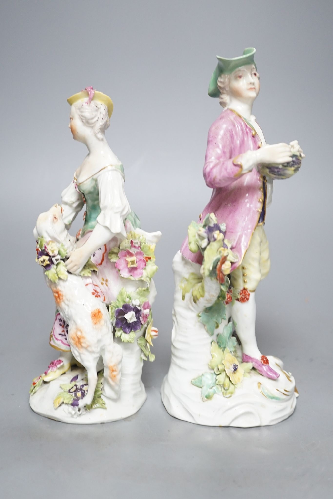 Two Derby porcelain figures of a gentleman holding a bird’s nest and a lady with a sheep, c.1760, 21.5 cms high.
